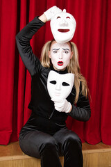 The focus is on a mime artist with a mask in his hand.