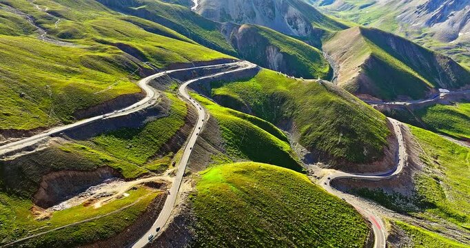 Asphalt highway road in the valley. Spectacular Duku highway and green hills natural landscape in Xinjiang. Duku highway is the most beautiful highway in China.