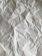 Crumpled Paper Texture: Abstract background featuring the detailed texture of crumpled white paper, showcasing its creases, folds, and shadows.