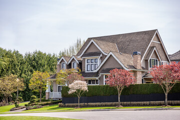 Two story stucco luxury house with nice spring blossom landscape in Vancouver, Canada, North...