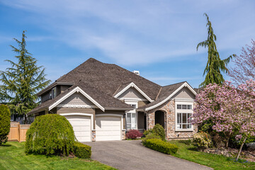 Two story stucco luxury house with nice spring blossom landscape in Vancouver, Canada, North America. Day time on June 2025.
