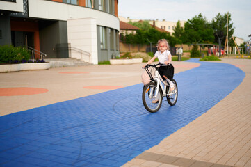 child biking on colorful path, showcasing outdoor activity and freedom. young girl with pink...