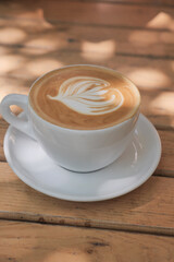 Smooth coffee with intricate design on wooden table
