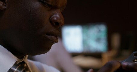A detective listens to an audio recording on a dictaphone while sitting at his desk. Close-up of...