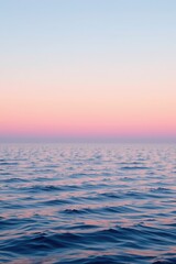 Obraz premium Serene Ocean Waves Under Soft Pink and Blue Sky at Dusk Near the Horizon Line
