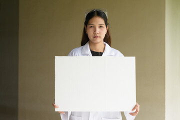 Scientist woman wearing lab coat and goggles holding placard with copy space