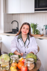 nutritionist in a white coat working at a table with fresh products and modern gadgets. nutrition...
