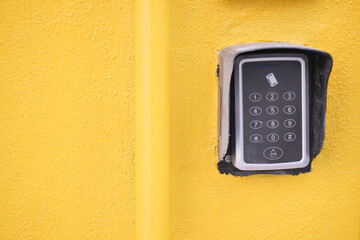 Keypad entry system on a bright yellow wall