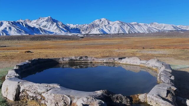 Winter early morning blue sky natural Hilltop Whitmore Wild Willys Hot Springs hot tub soak sunny sky snow covered Mammoth Mountain Minarets aerial drone Convict Canyon peaceful steam left slide