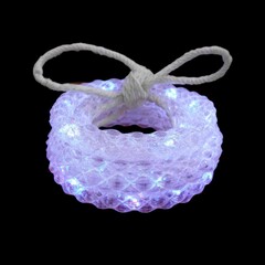 A coiled translucent rope light with a simple knot tied on top illuminated with white LEDs against a black background