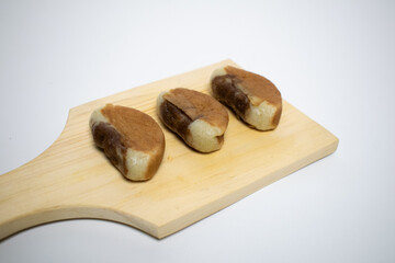 Three sweet pukis cakes placed on a wooden board, ready to be served or enjoyed.