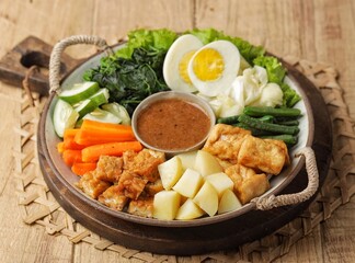 Gado-gado is a food consisting of vegetables, potatoes, tempeh, tofu, boiled eggs, etc. seasoned with peanut sauce and so on.