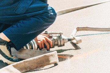 Firefighters attaching water hose on site