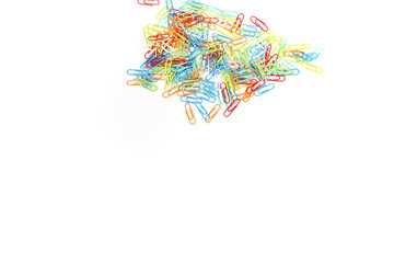 Fototapeta premium A vibrant cluster of colorful paper clips scattered on a clean, white background, creating a visually appealing stationery scene