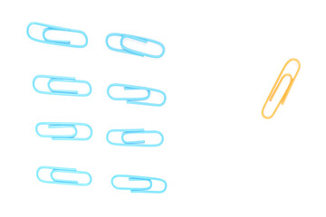 A Conceptual Image of Blue Paper Clips Grouped Apart from a Single Yellow One on White