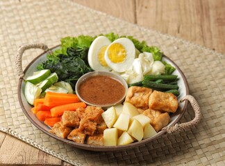 Gado-gado is a food consisting of vegetables, potatoes, tempeh, tofu, boiled eggs, etc. seasoned with peanut sauce and so on.