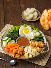 Gado-gado is a food consisting of vegetables, potatoes, tempeh, tofu, boiled eggs, etc. seasoned with peanut sauce and so on.