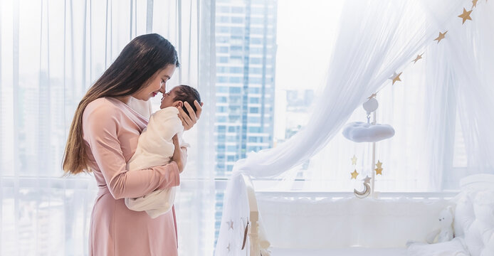 Closeup portrait of beautiful young asian Indian mother kissing newborn baby. Healthcare and medical Indian, home family love lifestyle asia mother’s day parenthood panoramic banner