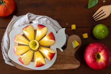 A close-up of a fresh red apple fruit on a round apple slicer.