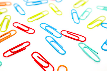 Colorful Paper Clips Scattered on a White Surface Creating a Playful Pattern