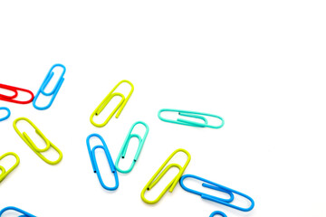 Colorful paper clips on white background, scattered stationery items in vibrant hues