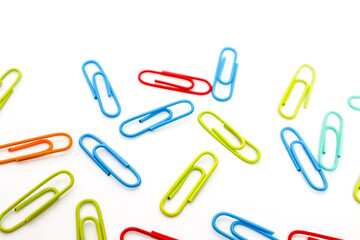 Colorful Paper Clips Scattered on a White Background, Perfect for Office or School Supplies