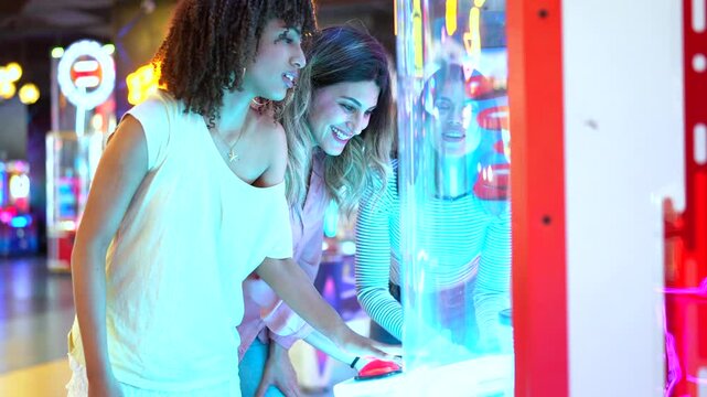 Friends playing arcade game together in summer