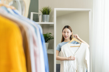 Choose clothes to wear, attractive asian young woman, girl try on appare, happy choice of shirt,...