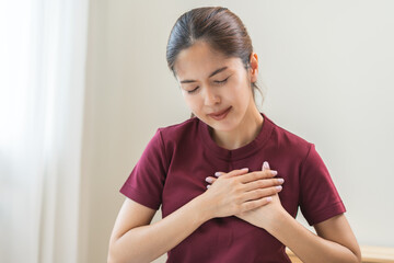 Heart attack, health care concept, suffering acute cardiac asian young woman hand touching on her...
