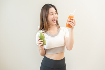 Orange, green detox juice, smile asian young woman hand holding bottle of vegetable juice, carrot...