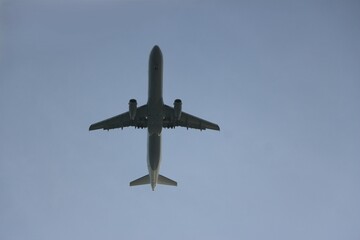 Una impresionante vista de un avión tomada desde abajo contra un cielo azul despejado. La aeronave...