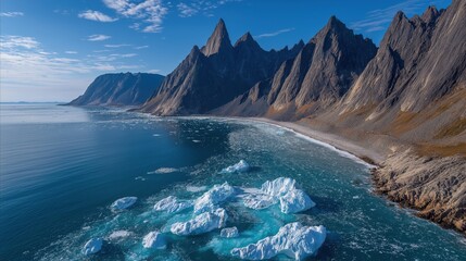Majestic arctic landscape featuring floating icebergs along rugged coastal mountain range