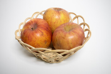 Three apples in a wicker basket