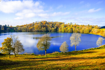 View of the Weinfelder Maar and the surrounding landscape. Nature in the Eifel region in autumn. Totenmaar near Daun.
