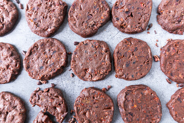 cacao nibs chocolate chunk cookies on grey background.