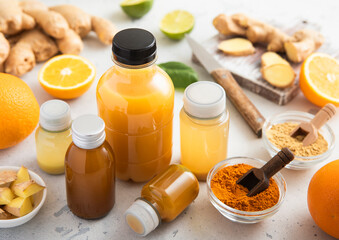 Various bottles of immune boost shot drink with ginger and orange and turmeric on light background.Vitamin boost drink.