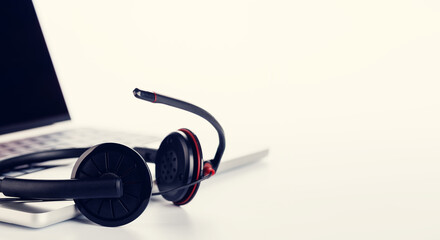A sleek headset resting on a laptop, set against a bright white background
