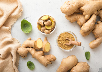 Fresh ginger root slices with melted ginger powder on light kitchen background.Top view.