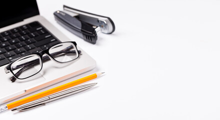 A clean and minimal desk setup featuring a laptop and a office supplies