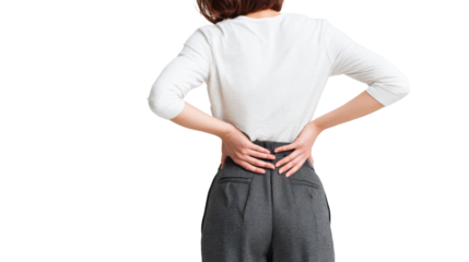 Woman experiencing back pain, wearing casual outfit, hands on lower back, isolated background.