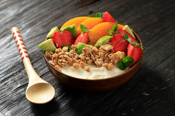 A Bowl of Granola Greek Yoghurt with Strawberry, Avocado, and Peach Topping