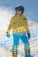 Braving the slopes, a young skier in vibrant gear pauses before embracing the thrill of winter...