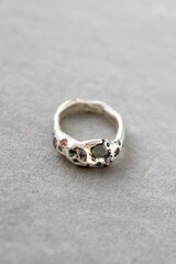 Handcrafted Silver Ring with Gemstones on Gray Background, Unique Jewelry, Fashion Accessory.