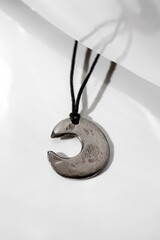 Unique Handmade Crescent Pendant on Cord. Modern Jewelry Design on White, Isolated Style.