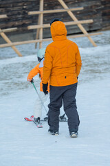 Ski instructor guides young learner on snow-covered slope in winter wonderland, fostering skills...