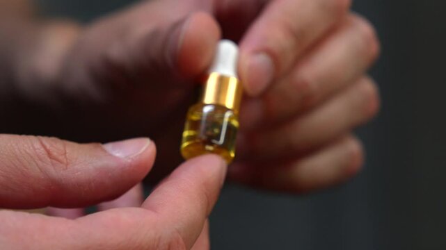 A small cosmetic bottle with a dropper of liquid inside.
Moisturizing oil in a bottle or a health product.
A small bottle with a dropper.
Cosmetology and beauty industry