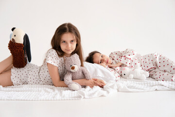 Pajama party. Happy children's laughter. Happy girls laughing, lying next to each other. Concept of childhood, leisure, friendship. happiness. Cheerful good morning!
