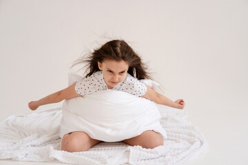 Portrait of cheerful positive relaxing girl getting ready for bed hugging pillow on white background. Good morning concept. Good sleep and healthy lifestyle.
