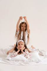 Pajama party. Happy children's laughter. Happy girls laughing, lying next to each other. Concept of childhood, leisure, friendship. happiness. Cheerful good morning. Vertical.
