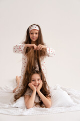Pajama party. Happy children's laughter. Happy girls laughing, lying next to each other. Concept of childhood, leisure, friendship. happiness. Cheerful good morning. Vertical.